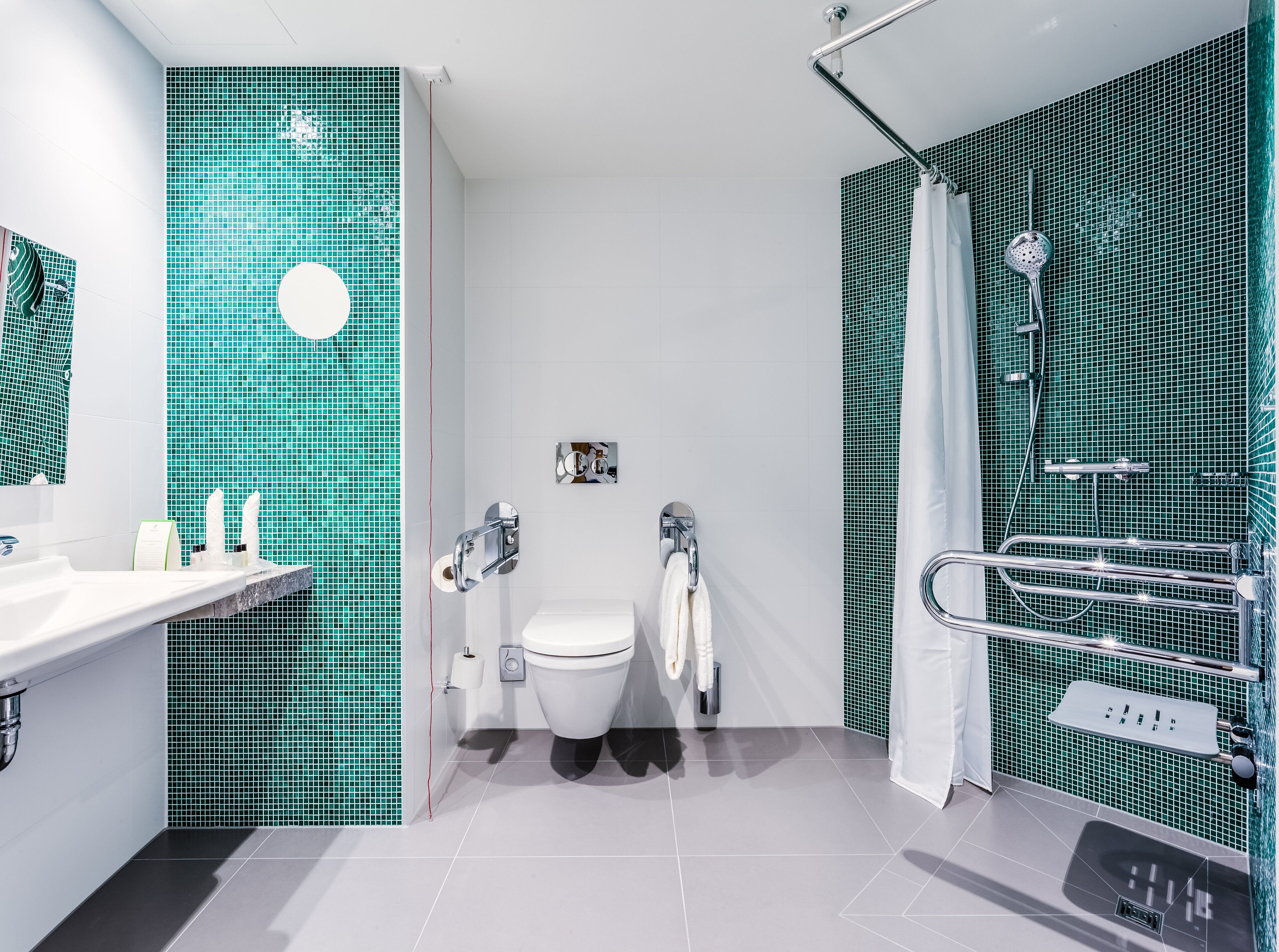 Une salle de bain moderne avec des toilettes blanches, un lavabo et un espace douche.