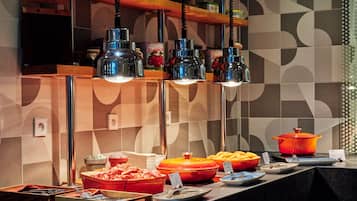 Un área de bufé con diferentes alimentos y utensilios para servir.