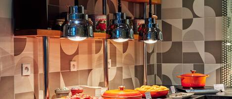 A buffet area with various food items and serving utensils.
