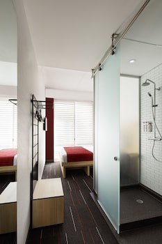 A small, modern room with a desk, chair, and a wall-mounted shelf with hooks. at Pod Times Square