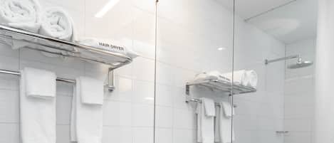 A modern bathroom with a white sink, wooden vanity, and a large mirror.
