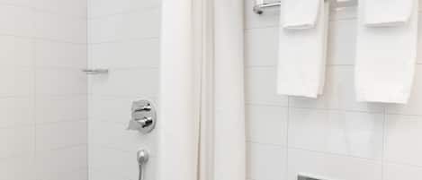 Une salle de bain moderne équipée d’une douche, de toilettes et d’un porte-serviettes.