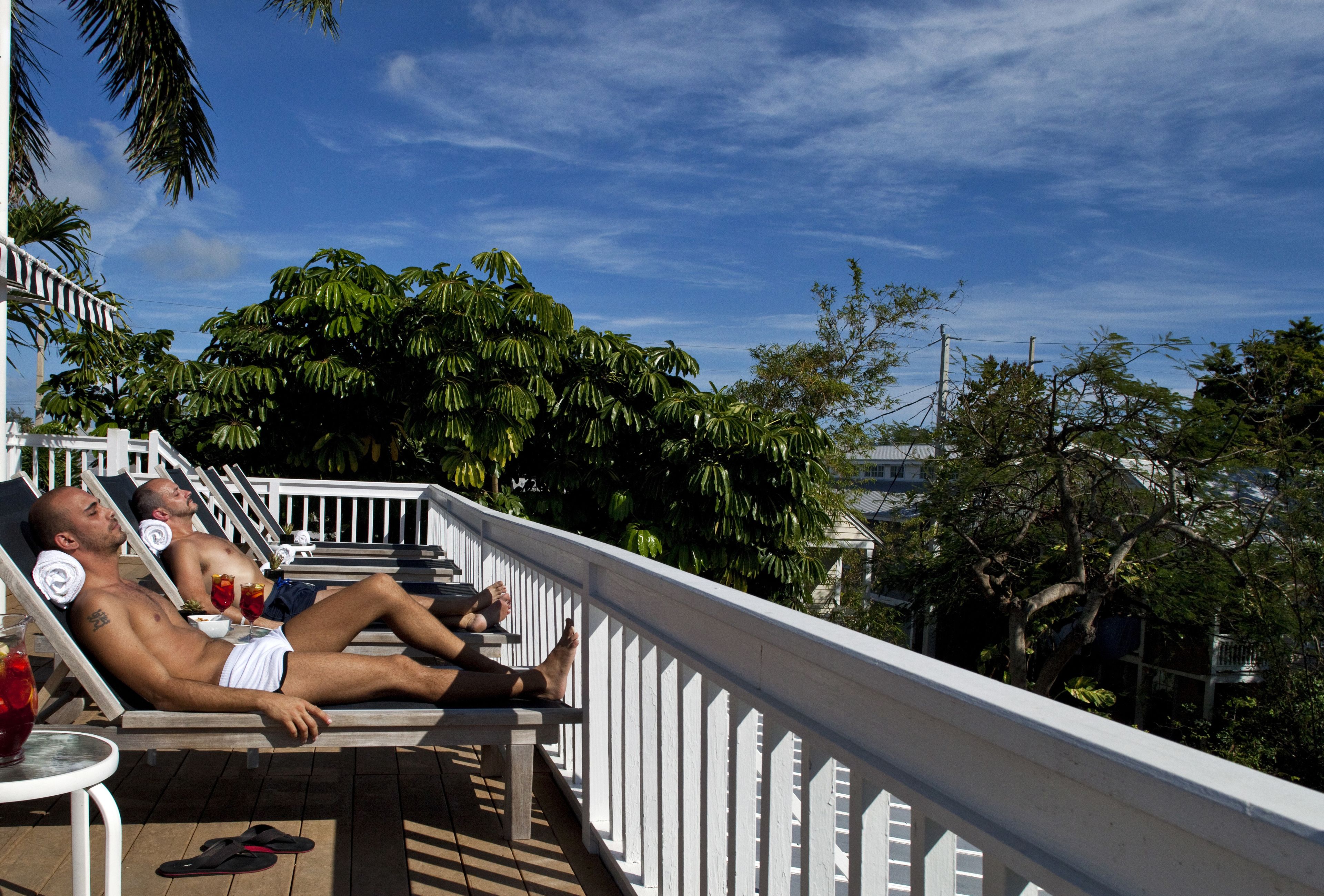 Een balkon met twee loungestoelen, een tafeltje en een leuning.