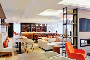 Un interior moderno con comedor, sofás y cocina al fondo.