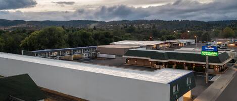 Un hôtel doté d’un toit plat, d’un parking et offrant une vue sur un paysage montagneux.