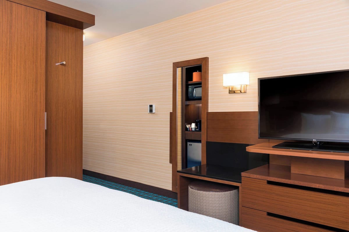 Escritorio, cortinas blackout y tabla de planchar con plancha