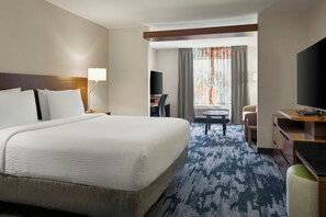 A hotel room with a large bed, a desk with a chair, a television, and a view of the outdoors. - Fairfield Inn & Suites by Marriott Indianapolis Fishers (Indianapolis)