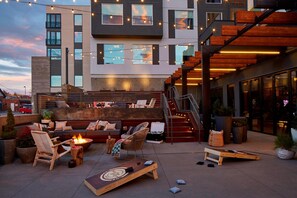 Un espace extérieur aménagé avec un foyer, des fauteuils et un canapé.