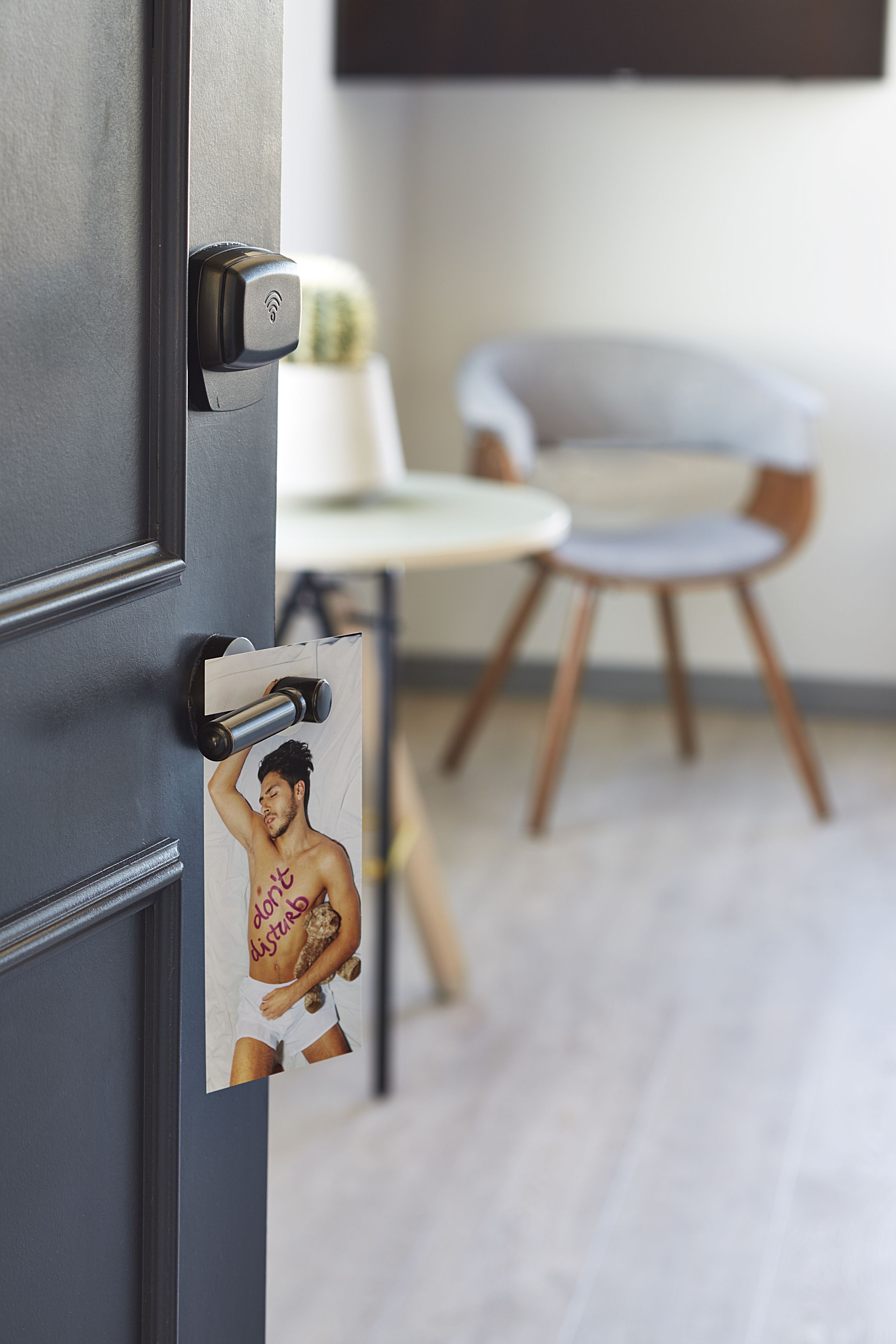 A door with a modern lock and a poster of a person holding a teddy bear.