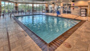 Una piscina interior con agua cristalina, suelo de baldosas y una banda de advertencia de 90 cent ímetros.