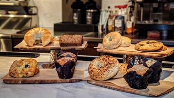 A variety of baked goods displayed on wooden boards in a bakery setting.