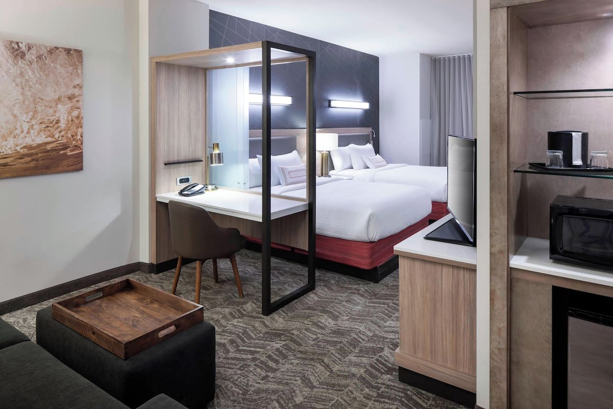 Ein Hotelzimmer mit Bett, Schreibtisch, Stuhl und Fernseher.
