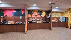 Ein Hotel-Rezeptionsbereich mit einem Holzboden, einem Kühlschrank und einer Kaffeemaschine.