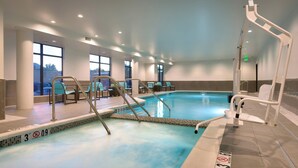 An indoor swimming pool with clear water, safety signs, and a sunlit room with windows and chairs. - Residence Inn by Marriott Flagstaff (Flagstaff)