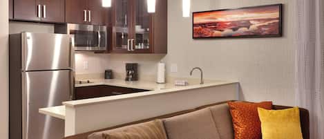 A modern kitchen with stainless steel appliances, a built-in island, and pendant lighting.