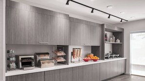 A modern kitchen with built-in appliances, a white countertop, and a large window. - TownePlace Suites by Marriott Charlotte Fort Mill (Fort Mill)