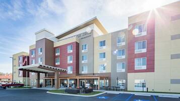 A multi-story hotel with a covered entrance and outdoor seating area.
