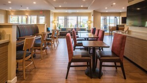 A spacious restaurant with high ceilings, multiple seating areas including booths and tables, and a large TV mounted on the wall. - TownePlace Suites by Marriott Cleveland (Cleveland)