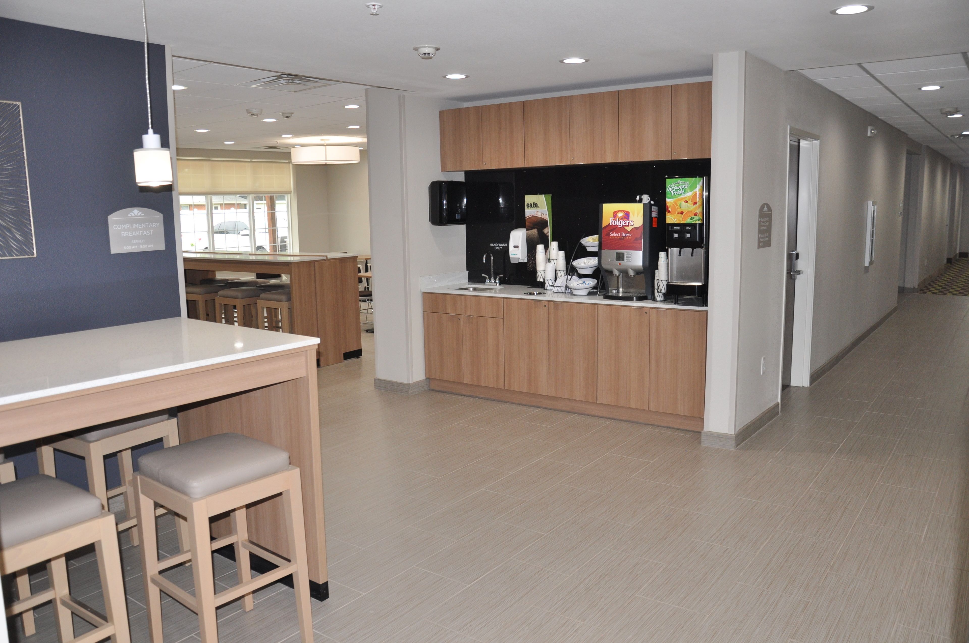 Eine moderne Hotellobby mit Empfangsbereich, Bar und Sitzgelegenheiten.