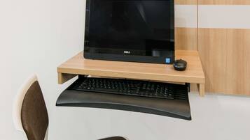 A Dell monitor on a wooden desk with a keyboard and mouse.