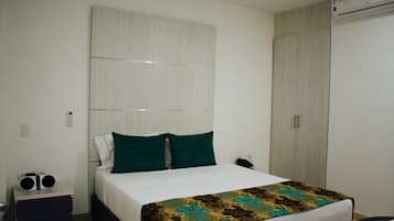 Une chambre d’hôtel équipée d’un lit, d’une table de chevet, d’une armoire et d’un appareil de climatisation.