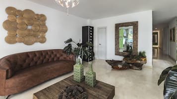 A modern living room with a brown sofa, green vases, and a wooden coffee table.