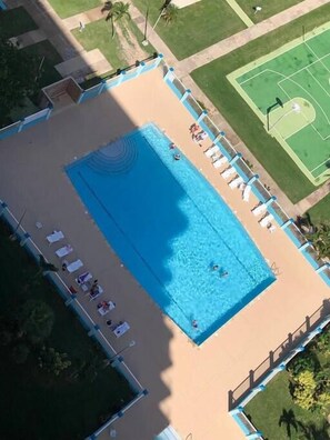 A rooftop swimming pool with lounge chairs and a tennis court. - ENCHANTED Jewel @ Playa Azul Luquillo Beach 9th Floor (Luquillo)