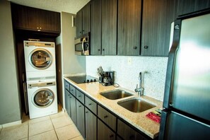 A compact kitchen with a washing machine, a microwave, and a refrigerator. - ENCHANTED Jewel @ Playa Azul Luquillo Beach 9th Floor (Luquillo)