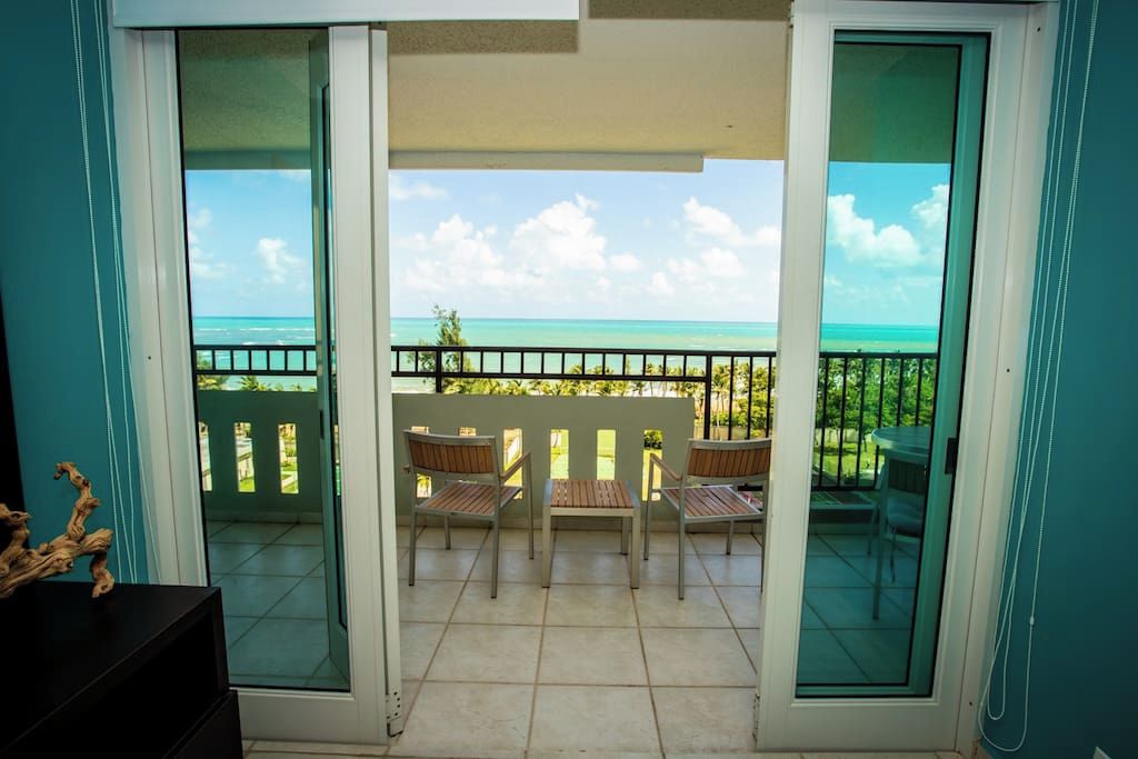 Ein Balkon mit Blick auf das Meer, einem Tisch und zwei Stühlen.