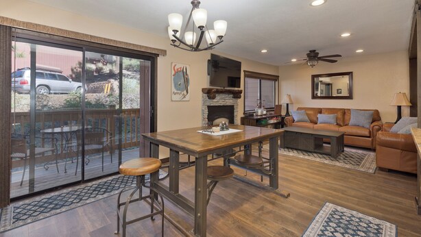 A spacious living room with a wooden dining table, leather sofa, and a fireplace. - Mammoth Condo, 2 Beds+ 2 Baths, Next To Canyon Lodge-Mammoth Ski & Racquet Club (Mammoth Lakes)