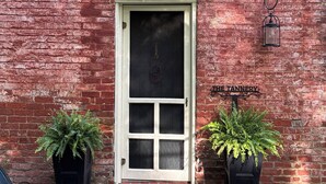 A brick building with a white-framed door, two potted ferns, a stone-paved entrance, and a sign reading 'THE TANNERY.' - The Tannery!  Private Dipping Pool In The Warm Springs Stream!  Pet Friendly!  (Warm Springs)