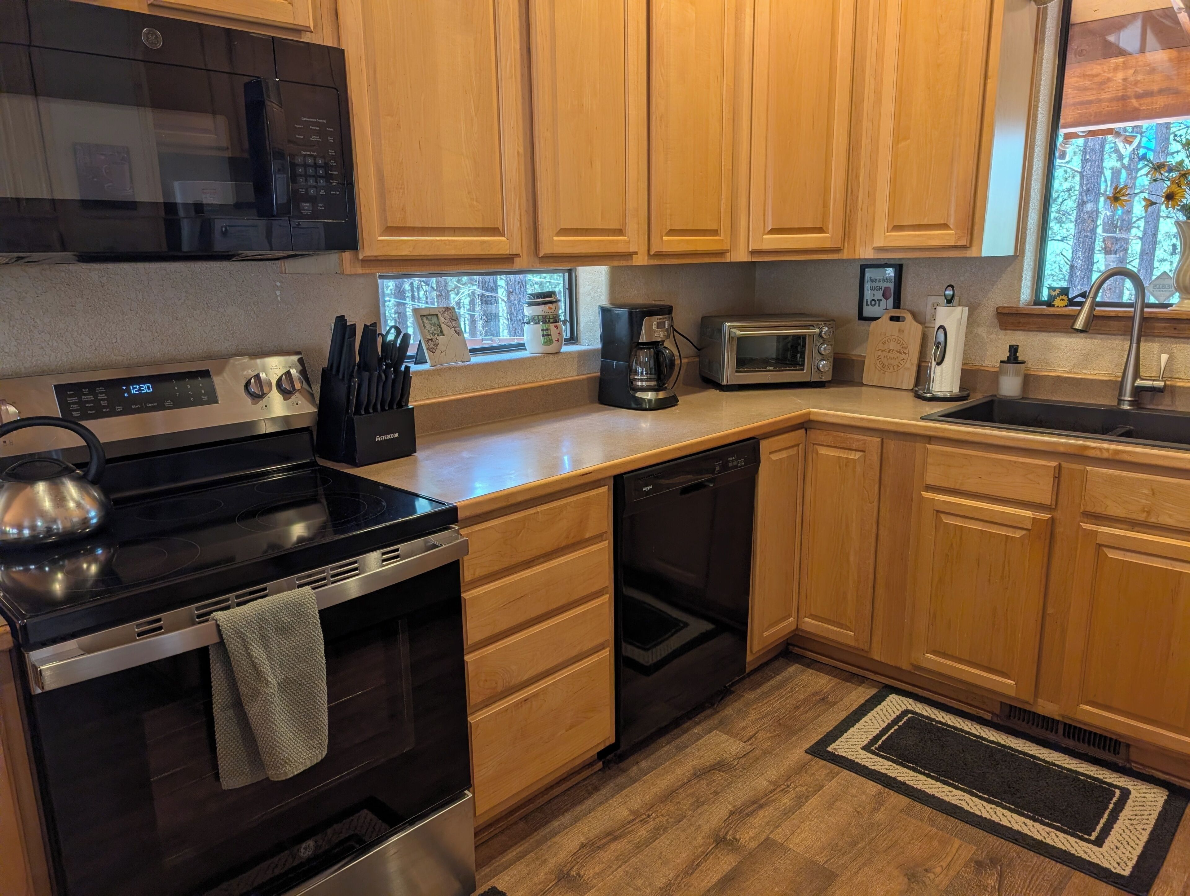 A kitchen with wooden cabinets, a microwave, a toaster, and a dishwasher.
