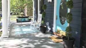A porch with a white chair, a welcome mat, and potted plants. - Serene Sauna Retreat with Chefs Kitchen, Luxury Beds & Luxury Baths (West Point)