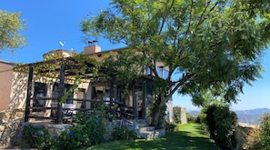 A rustic villa with a stone facade, a wooden porch, and a lush garden.