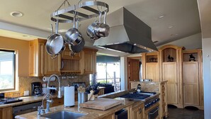 A modern kitchen with granite countertops, stainless steel appliances, and wooden cabinetry. - Private Vineyard Estate Overlooking Pacific Ocean (Malibu)