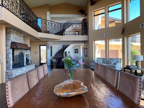 A spacious living area with a large wooden table, leather sofas, and a stone fireplace. - Private Vineyard Estate Overlooking Pacific Ocean (Malibu)
