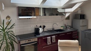 Una cocina moderna con tragaluces, horno empotrado, un lavabo y un microondas.
