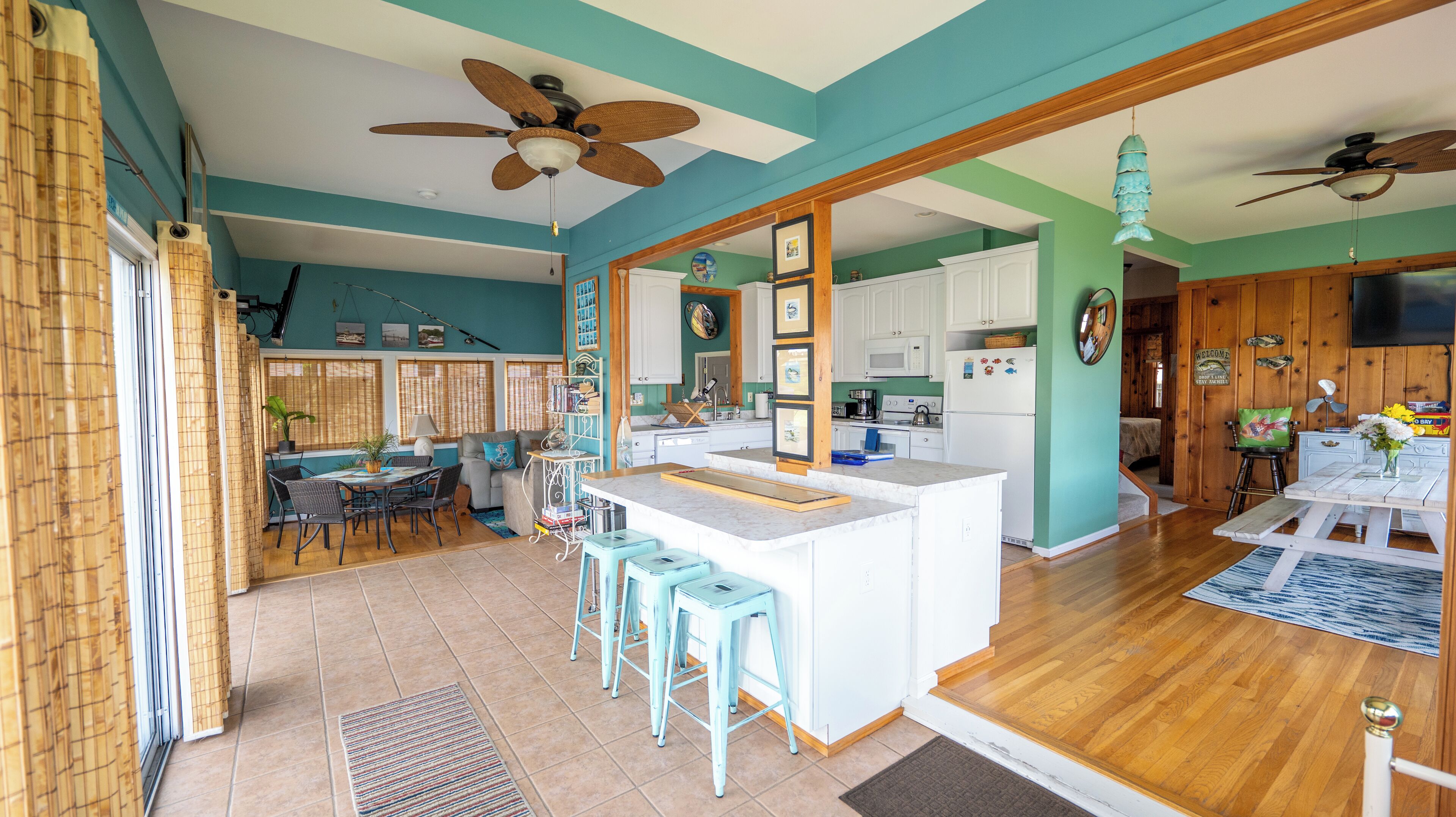 A spacious kitchen with a central island, wooden cabinets, and a dining area with a table and chairs.