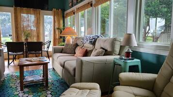 A cozy living room with a sofa, chairs, a coffee table, and a patterned rug.