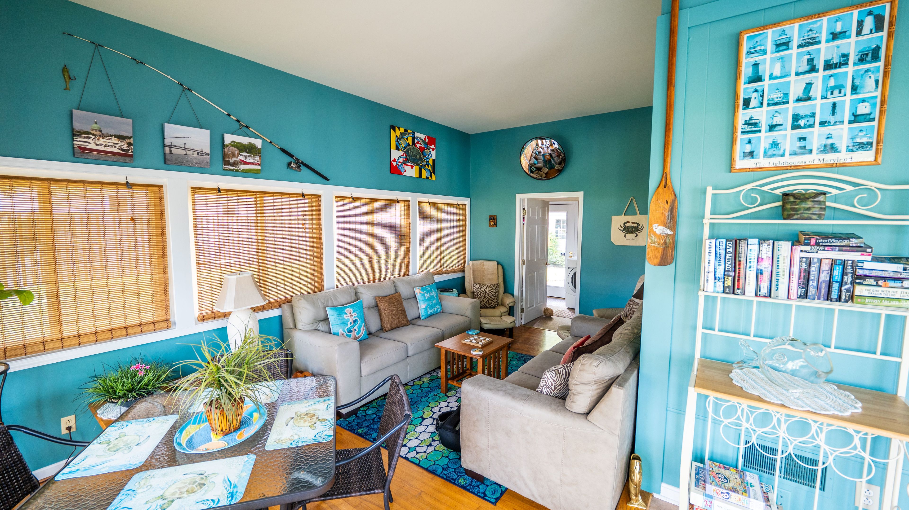 A living room with a teal wall, a sofa, a coffee table, and a bookshelf.