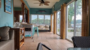 A spacious living room with a large window, a ceiling fan, and a sofa.