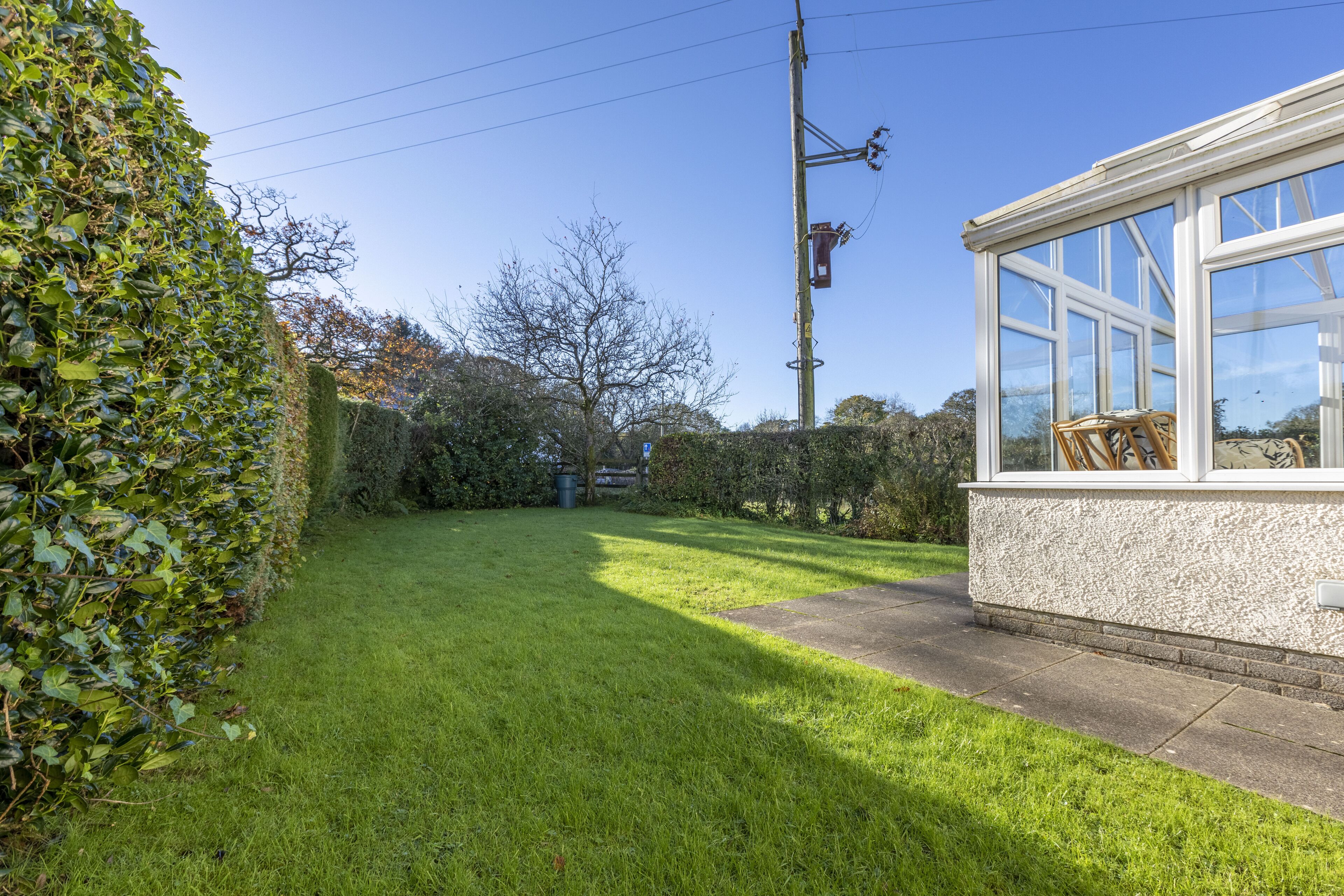 A well-maintained garden with a clear pathway leading to a building with large windows and a white exterior.