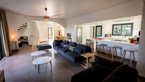 A modern living room with a sofa, two small tables, and a unique ceiling light. - New: Villa 200 m2 with sea view and heated swimming pool, 4 bedrooms. (Porto-Vecchio)