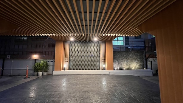 Un espacio interior con un diseño de techo moderno, una pared estampada y un suelo de piedra.