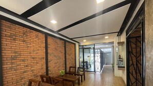 A modern interior with brick walls, wooden furniture, and a glass door leading to another room. - Chonlapruk Lakeside Hotel (Khon Kaen)