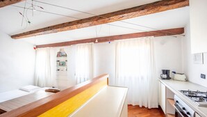 A compact kitchen with wooden beams, a white countertop, and a stove. - Ca' Marina, a few steps from the Biennale di Venezia (Venezia)