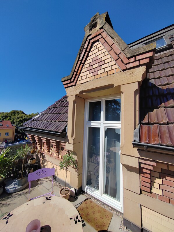 Ein Haus mit Ziegelaußenwand, großem Fenster und einem Ziegeldach.
