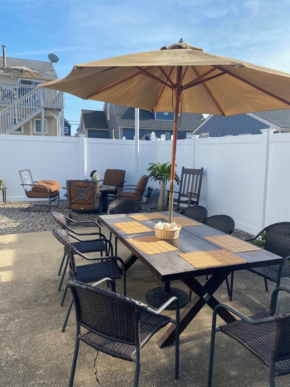An outdoor patio with a table, chairs, and an umbrella.