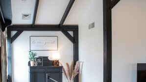 A staircase with a black railing leading to a landing with a desk and a framed welcome sign.