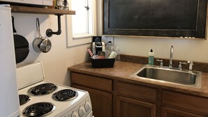 A kitchen with a stove, microwave, and a blackboard above the sink. - Cut Bank Unit #1 near Glacier National Park! (Cut Bank)